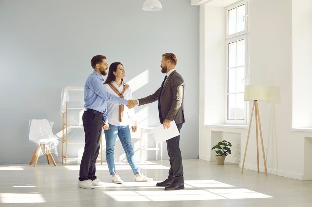Photo of a man and woman shaking a mans hand.